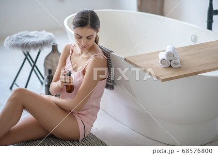 Young cute woman in lingerie sitting in the bathroom 68576800