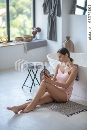 Young cute woman sitting in the bathroom Young cute woman sitting in the bathroom 68576801