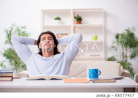 Young male student preparing for exams at home Young male student preparing for exams at home 68577457