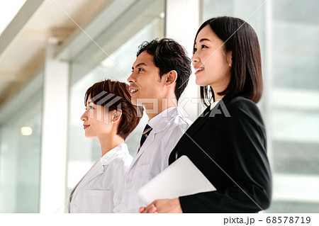 病院で並ぶ白衣の医者とスーツ姿のMRの女性 病院で並ぶ白衣の医者とスーツ姿のMRの女性 68578719