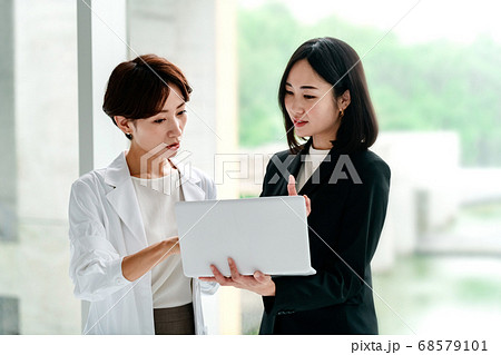病院でミーティングする女医とビジネスウーマン 病院でミーティングする女医とビジネスウーマン 68579101