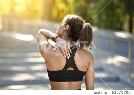 Back view of black sporty girl rubbing her spine 68579706