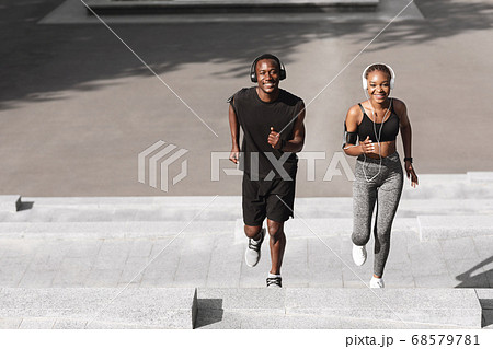 Couple Activities. Sporty Man And Woman Running Up Steps In Urban Park 68579781
