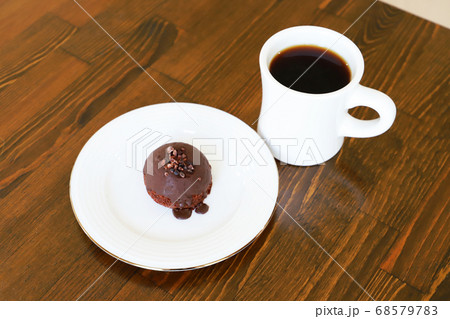木製テーブルにあるホットコーヒーとチョコケーキ 68579783