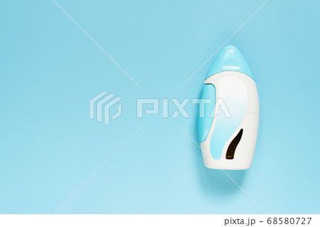 Steroid nasal spray suspension with blank label on light blue background. Medical device used to treat allergic rhinitis, hay fever, sinusitis or nasal polyps. Health care concept. 68580727