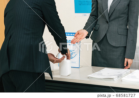 来場時にアルコール消毒をするビジネスマン 68581727