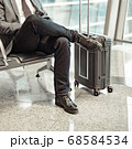 man waiting for his flight at the airport and looking at a mobile phone 68584534
