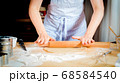 Female hands rolling out dough on kitchen table, close up 68584540