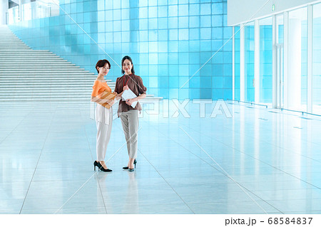 オフィスのエントランスでミーティングするカジュアル服の女性2人 オフィスのエントランスでミーティングするカジュアル服の女性2人 68584837