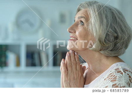 Portrait of a beautiful senior woman praying 68585789