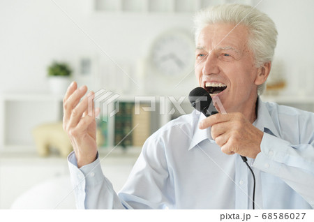 Portrait of senior man singing with microphone Portrait of senior man singing with microphone 68586027