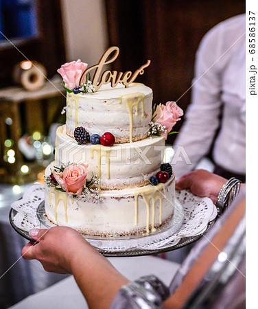 Beautiful wedding cake with cream With text Love on top pink flowers roses 68586137
