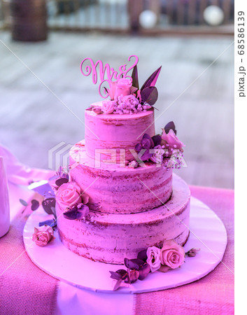 Beautiful wedding cake with cream With text MR MRS on top pink flowers roses 68586139