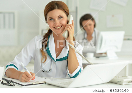 Doctor sitting at desk at work in hospital Doctor sitting at desk at work in hospital 68586140