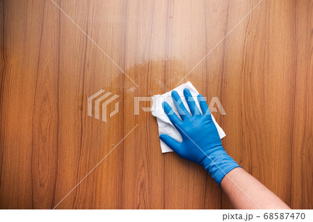 hand holding spray bottle and cleaning table  68587470