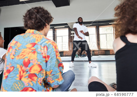 Young sporty man teaching dancing in studio Young sporty man teaching dancing in studio 68590777