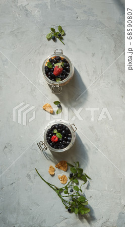 Desserts made from fresh berries in small glass jars. Layout on a grey background, vertically 68590807