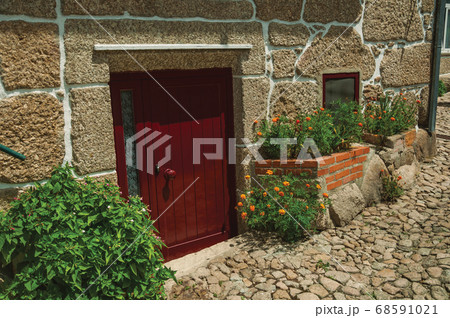 Facade of stone house with a wooden door Facade of stone house with a wooden door 68591021