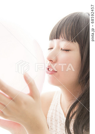 風船にキスをする女性の写真素材