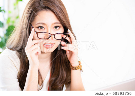 仕事中に眼鏡を外す若い女性の写真素材