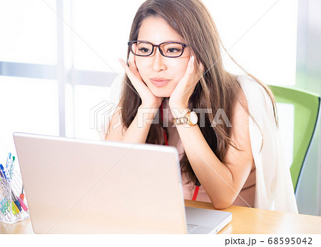 机に肘をつく眼鏡をかけた若い女性 机に肘をつく眼鏡をかけた若い女性 68595042