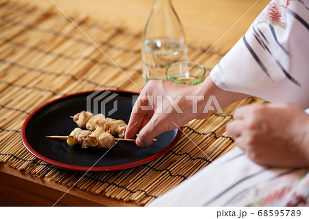 日本酒と焼き鳥を食べる和服姿の女性の写真素材 68595789 Pixta