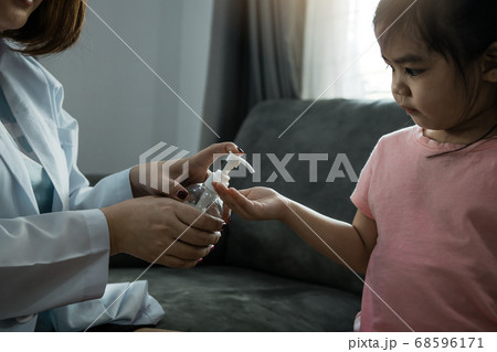 Female pediatrician is holding a bottle of alcohol 68596171