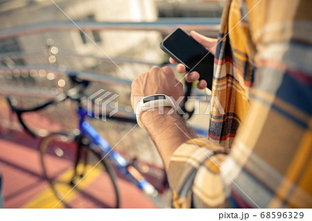 Male hands with wrist electronic watch and smartphone 68596329