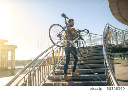Man with bicycle on the city bridge 68596360
