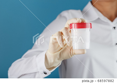 Semen analysis in a Bank is held in the hand of a 68597882