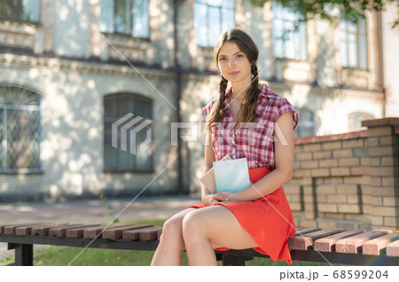 Young girl student on a bench in the daytime Young girl student on a bench in the daytime 68599204