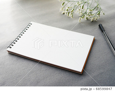 グレー背景にメモとペン 花がおしゃれ シックなイメージの写真素材