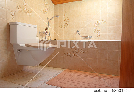 Very old toilet in a brown bathroom 68601219