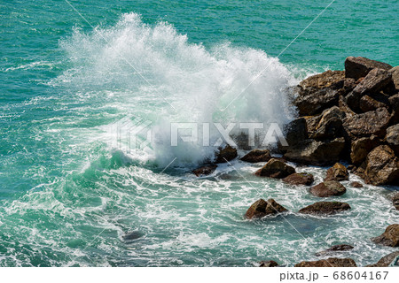 Sea waves break on the rocks - Breakwater in Liguria Italy 68604167