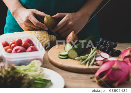 Woman preparing fresh fruits and vegetables for cooking salad, Healthy vegan food 68605482