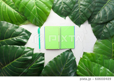 high angle view of open notepad on green leaf background high angle view of open notepad on green leaf background 68608489
