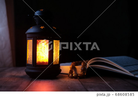 Ornamental Arabic lantern with burning candle glowing at night. 68608585