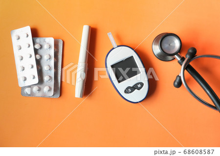 top view of diabetic measurement tools and pills on orange background  68608587