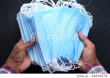 man hand holding surgical face mask, top view  68608978