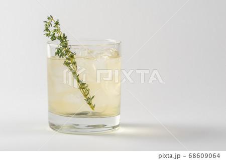 Alcoholic cocktail decorated with thyme in a glass Alcoholic cocktail decorated with thyme in a glass 68609064