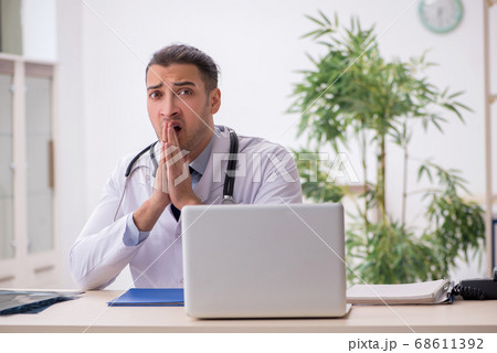 Young male doctor working in the clinic Young male doctor working in the clinic 68611392