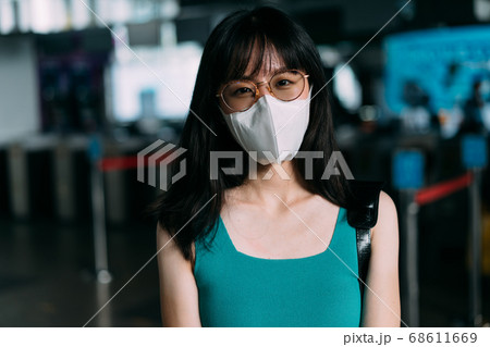 Asian woman wearing protective mask looking at camera 68611669