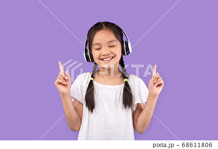 Girl In Earphones Enjoying Listening To Music, Purple Background Girl In Earphones Enjoying Listening To Music, Purple Background 68611806