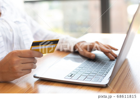 Woman using laptop and credit card at home Woman using laptop and credit card at home 68611815