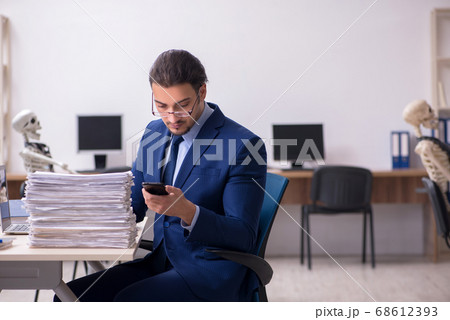 Young male employee with skeletons in the office 68612393