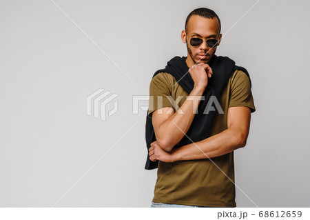 african-american young man in green t-shirt over light grey background with copy space african-american young man in green t-shirt over light grey background with copy space 68612659