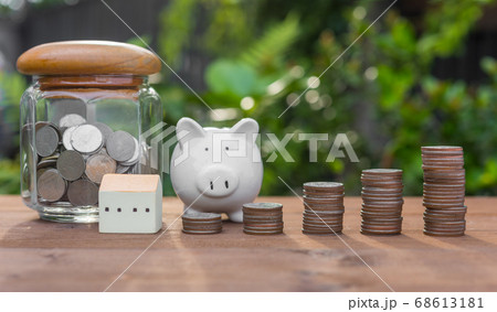 Piggy bank,money coins and house model on wood Piggy bank,money coins and house model on wood 68613181
