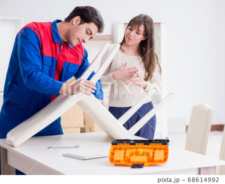 Contractor repairman assembling furniture under woman supervisio 68614992