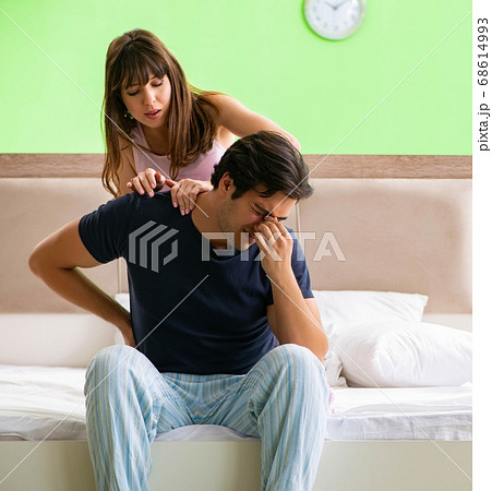 Woman doing massage to her husband in bedroom 68614993