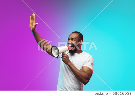 African-american young man's portrait on gradient studio background in neon 68616053